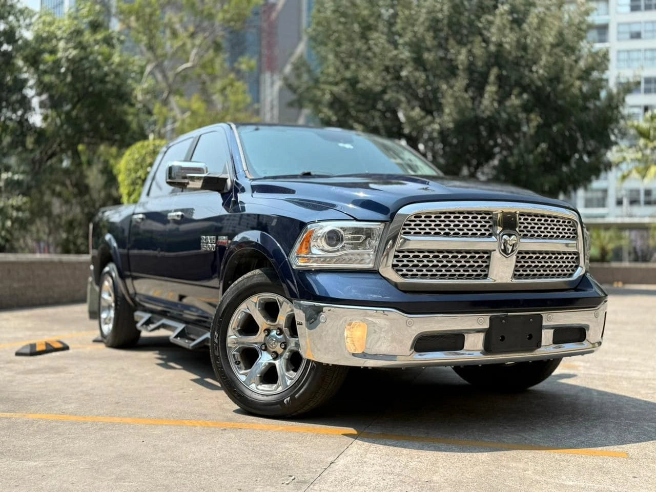 Camioneta Dodge RAM 1500 Laramie 2017 en color gris, vista lateral mostrando detalles de la pickup.
