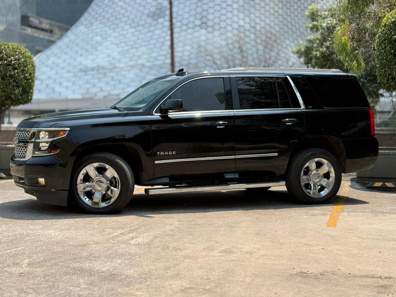 SUV Chevrolet Tahoe LT 2017 de color gris oscuro, vista lateral del vehículo en excelente estado.