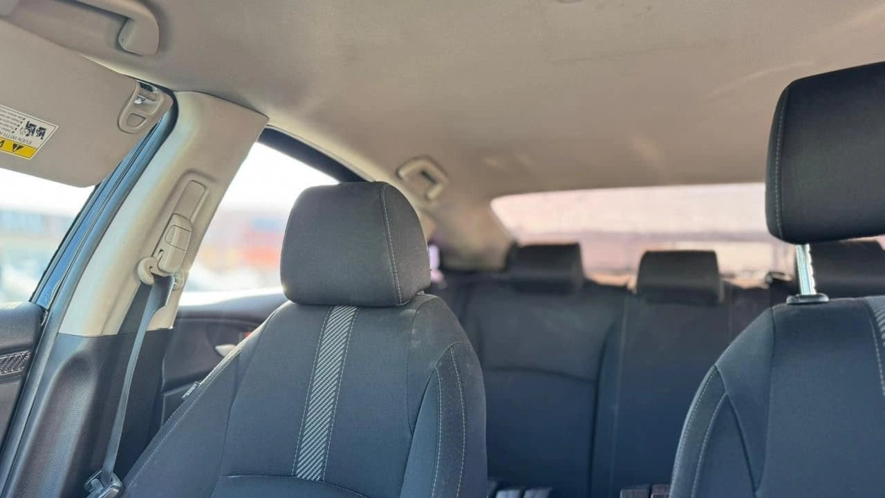 Sedán Honda Civic LX 2017 de color gris, vista lateral del vehículo en un entorno urbano.