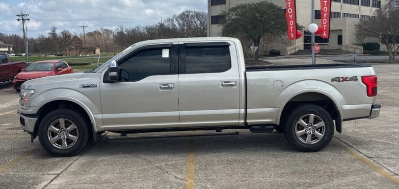 Camioneta Ford F150 Lariat 2018 en color azul oscuro, vista lateral, con detalles de carrocería y ruedas.