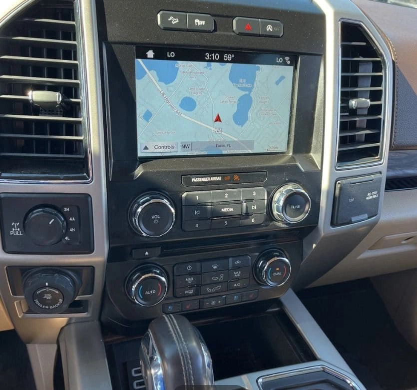 Camioneta pickup Ford F150 Lariat 2018 en color azul oscuro, vista lateral mostrando cabina y ruedas delanteras.