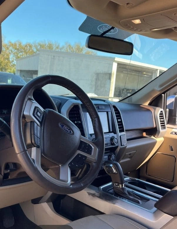 Camioneta Ford F150 Lariat 2018 en color negro, vista lateral, con detalles del diseño exterior, en un entorno urbano.