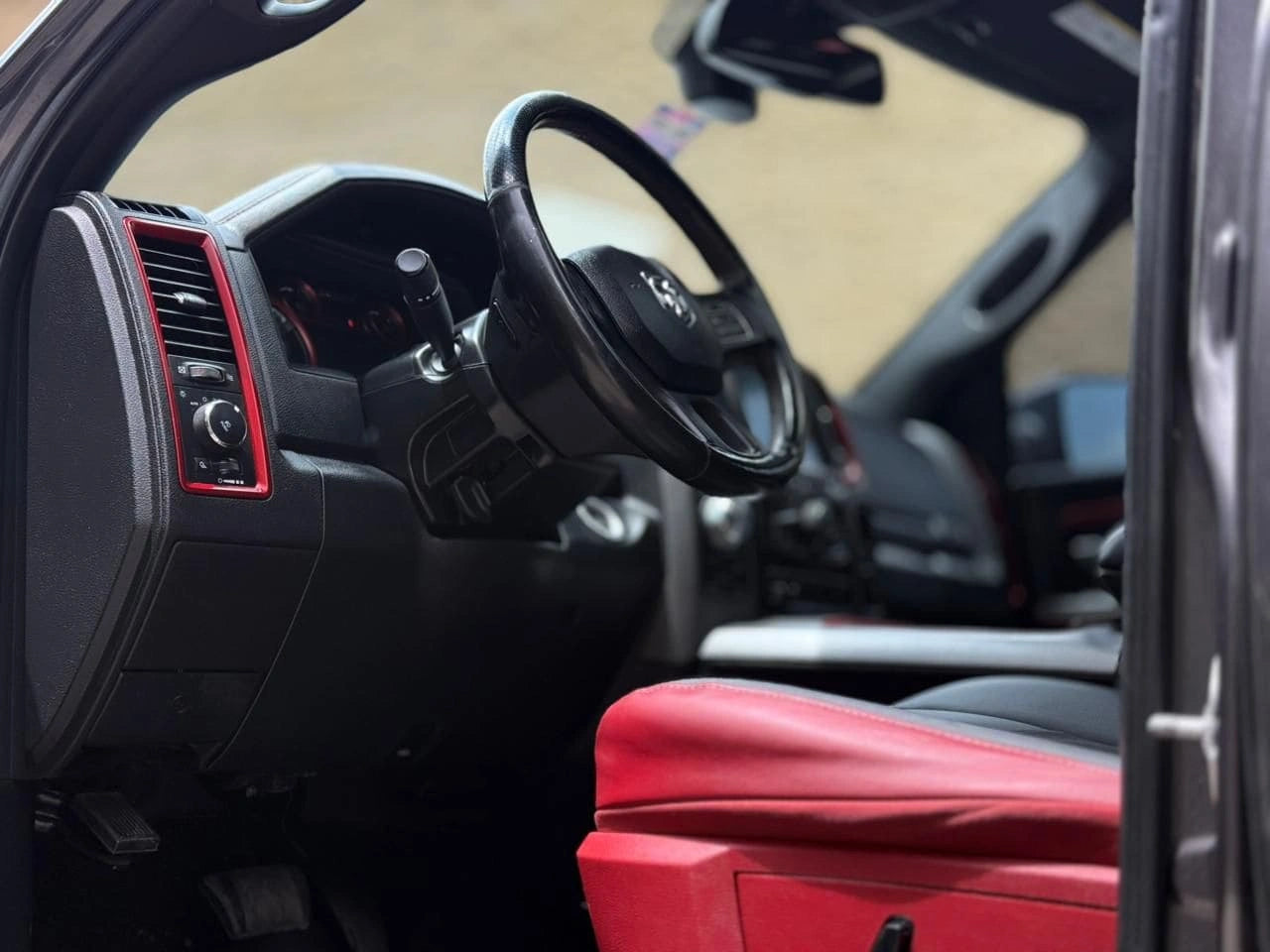 Camioneta pickup Dodge RAM 1500 Rebel 4x4 2017, vista lateral con detalles del vehículo rojo y ruedas grandes.