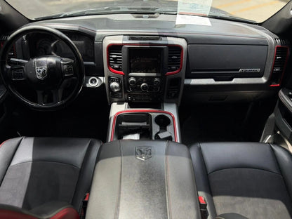 Camioneta pickup Dodge RAM 1500 Rebel 4x4 2017 en color negro, vista lateral, en carretera con fondo natural.