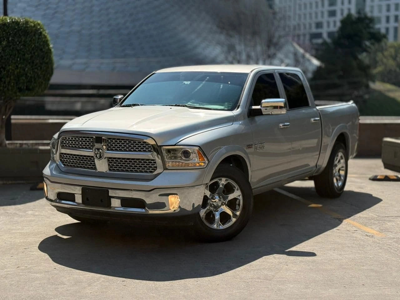 Camioneta pickup Dodge RAM 1500 Laramie 2017 en color gris, vista lateral mostrando detalles del vehículo.