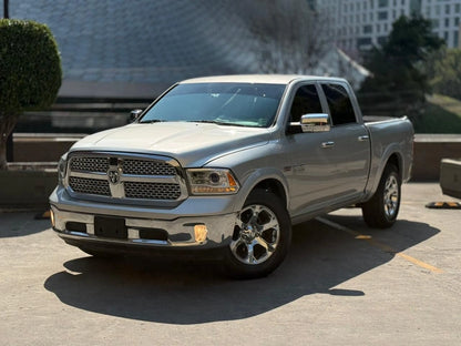 Camioneta pickup Dodge RAM 1500 Laramie 2017 en color gris, vista lateral mostrando detalles del vehículo.