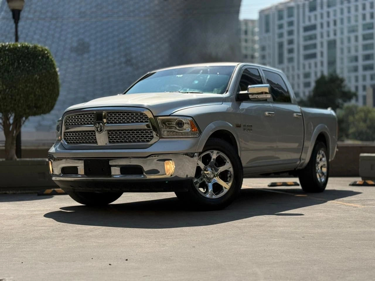 Camioneta Dodge RAM 1500 Laramie 2017 de pickup, vista frontal en color gris, en un entorno urbano.