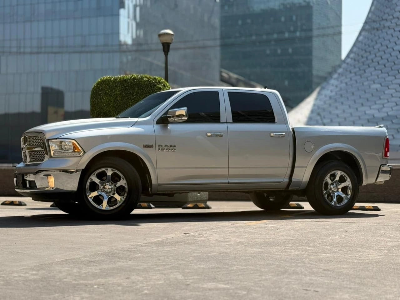 Camión pickup Dodge RAM 1500 Laramie 2017 de la marca Carmexio CDMX, vista lateral del vehículo en color gris.