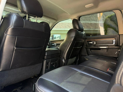 Camión pickup Dodge RAM 1500 Laramie 2017 en color gris, vista lateral, en buen estado, en un entorno urbano.