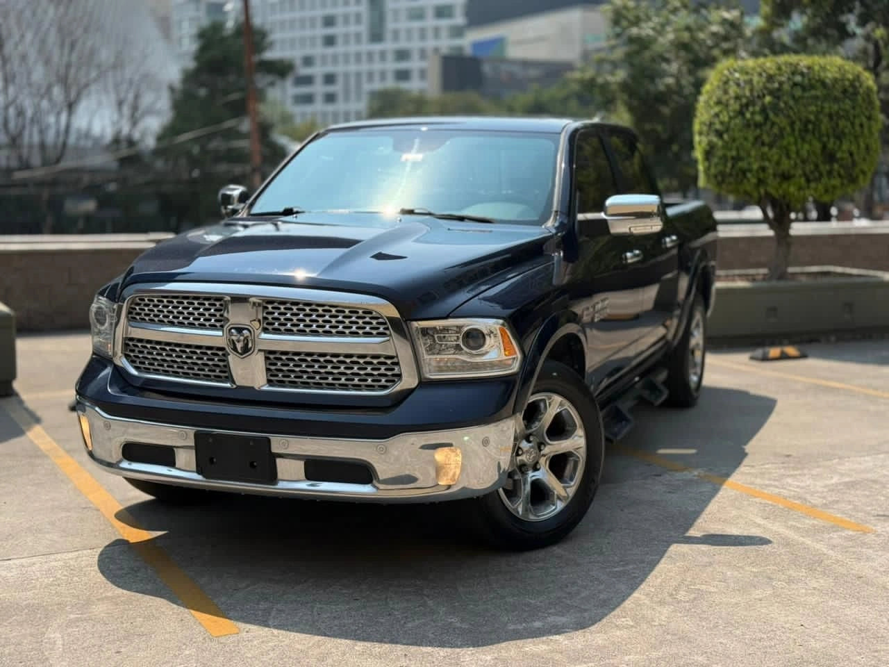 Camioneta Dodge RAM 1500 Laramie 2017 de tipo pickup en color gris con detalles en su interior y ruedas grandes.
