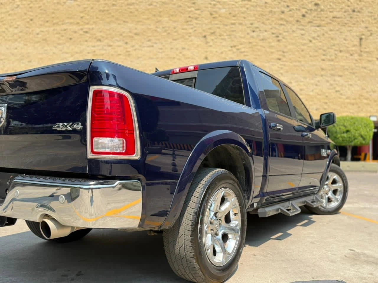 Camioneta Dodge RAM 1500 Laramie 2017 en color gris, vista lateral, mostrando el diseño de la pickup de tamaño completo.
