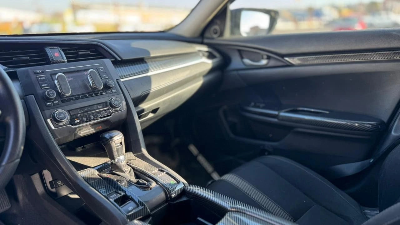 Sedán Honda Civic LX 4x4 2017 en color gris, vista lateral mostrando su diseño aerodinámico y detalles de las ventanas y ruedas
